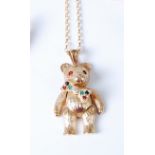 A modern 9ct gold teddy-bear pendant, having jointed limbs and paste set eyes and bowtie, 3.4cm (
