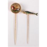 Two stick pins of sporting interest: a reverse painted intaglio stick pin of a game bird, with red