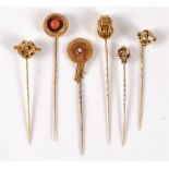 Six stick pins: to include an Etruscan revival coral stick pin, 16.5mm diameter; a seed pearl and