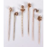 Six stick pins: to include a 9ct seed pearl and red hardstone flowerhead cluster stick pin, 7mm