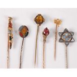 Six gemset stick pins: a multi gemset dirk stick pin, (unmarked, tests as approx. 14ct gold or