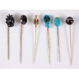 Six gemset stick pins: a banded agate and blue enamel snake stick pin, set with red hardstone