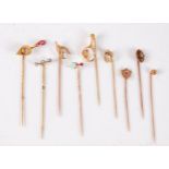 Nine variously gemset stick pins: a ruby and diamond set trowel stick pin, 22mm wide; a three