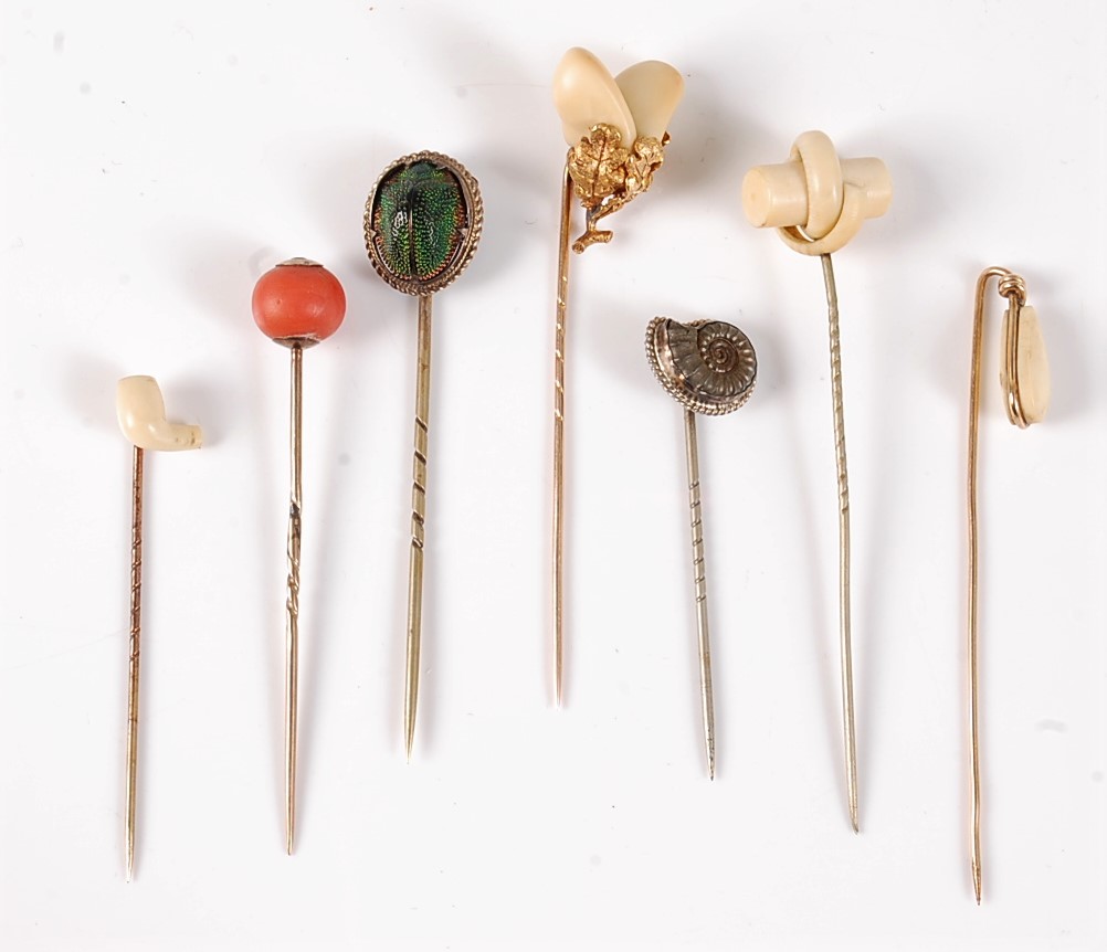 Seven stick pins: a stags tooth stick pin, the two teeth set as an acorn among oak leaves, 18mm