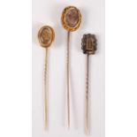 Three hairwork stick pins: an oval plaited hairwork stick pin, with glazed panel with painted