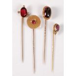 Four gemset stick pins: to include an oval garnet cabochon stick pin, collet mounted with closed