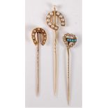 Three stick pins: a 15ct split pearl stick pin, 14mm wide; an unmarked pearl set horseshoe stick pin