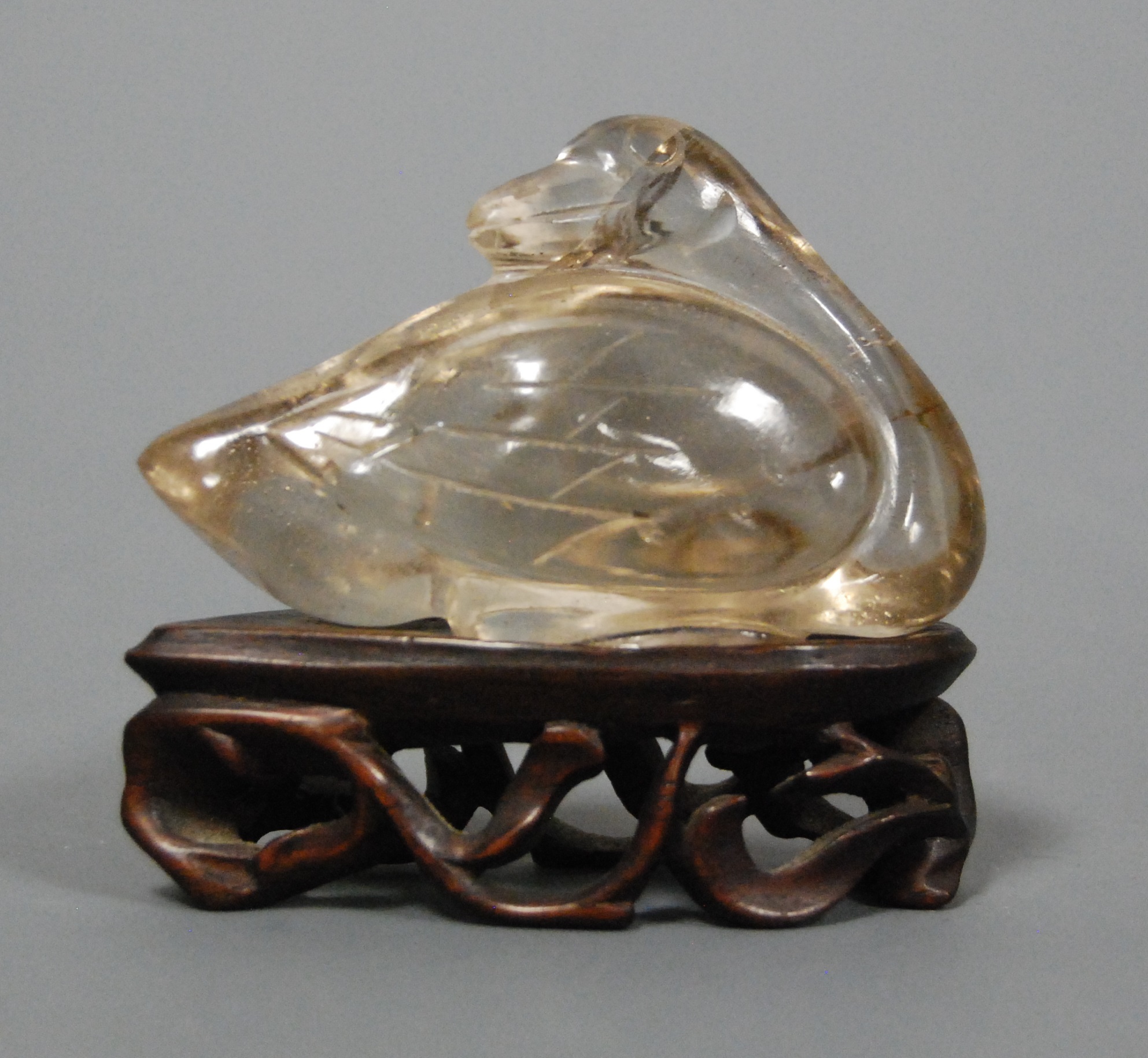 A Chinese quartz carving of a bird on pierced hardwood base