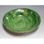 A 19th century green glazed pottery charger, dia. 37cm