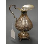 An early 20th century continental (Portugese?) white metal ewer having leaf etched decoration with a