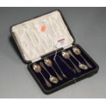 A cased set of six George V silver teaspoons with matching sugar bows in fitted leather case by John