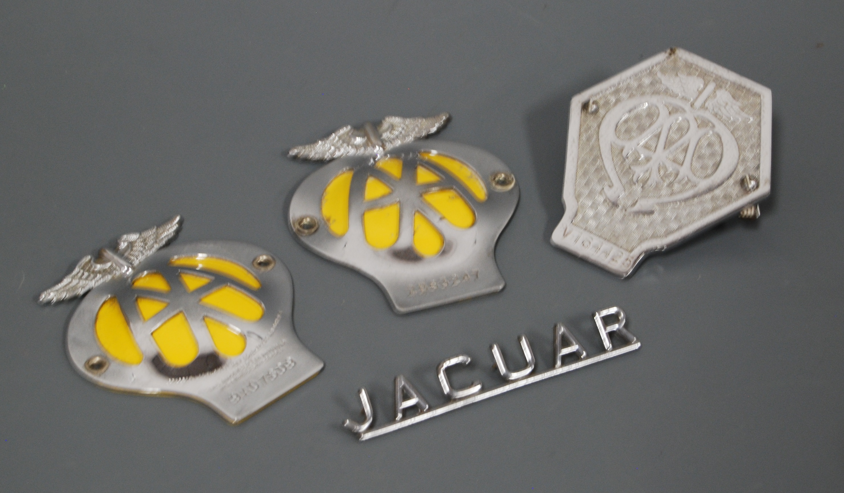 Three chrome AA car badges together with one other Jaguar car title