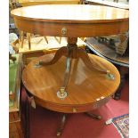 A pair of Regency style mahogany and ebony strung circular pedestal drum centre tables, having dummy