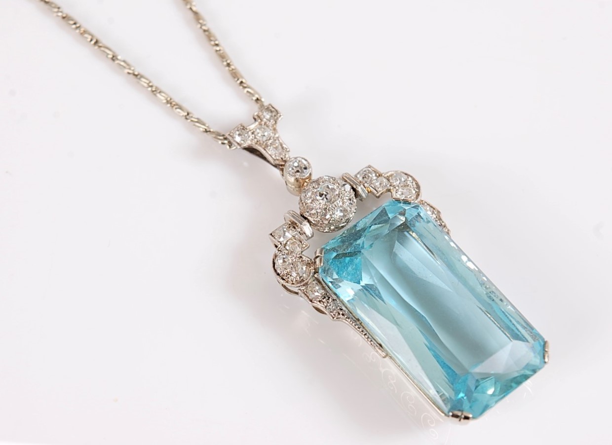 An Art Deco aquamarine and diamond pendant, the emerald cut aquamarine measuring, approx. 27 x 15.