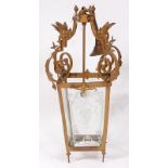 A gilt metal hanging lantern, set with winged griffin on wrought supports, the lantern with four