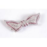An early 20th century 18ct ruby and diamond bow brooch, the bow modelled as a knotted undulating