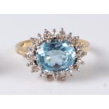 An 18ct gold, aquamarine and diamond ring, arranged as a central oval cut claw set aquamarine