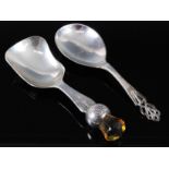 A George V silver caddy spoon, having a shaped bowl, the stem in the form of a thistle and