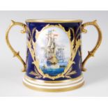 A Lynton Porcelain Company loving cup, decorated with opposing reserves of British naval frigates,