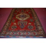 ***WITHDRAWN*** A Turkish woollen carpet, the rust coloured field decorated with medallions and