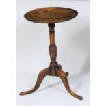 A George III faded mahogany pedestal tripod table, having a dished tilt-top on a gun barrel turned