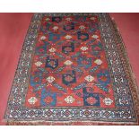 A circa 1900 Persian woollen Kazak rug, the red ground decorated in the pinwheel pattern within