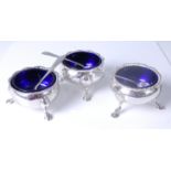 A matched set of three George III silver table salts, each with gradrooned rims, blue glass