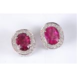 A pair of pink sapphire and diamond cluster earrings, the oval raspberry pink sapphires, each