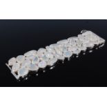 A contemporary moonstone cuff/bracelet, the mixed cut moonstone cabochons in textured collet mounts,