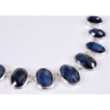 A contemporary sapphire necklace, the graduated oval faceted sapphire cabochons, between approx.