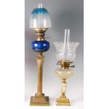 A late Victorian brass pedestal oil lamp, having a blue glass and acid etched shade, with blue glass