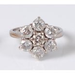 An 18ct white gold diamond set flower head cluster ring, arranged as seven claw set old