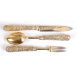 A George IV silver gilt dessert knife, fork and spoon, the loaded handles each worked as fruiting