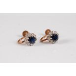 A pair of 9ct sapphire and diamond earrings, the round sapphires surrounded by small round diamonds,