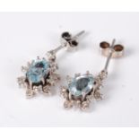 A pair of white metal, aquamarine and diamond ear pendants, the six claw set oval cut aquamarines