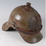 A Prussian Artillery? steel helmet, olive painted with pressed brass eagle plate, national