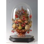 A Victorian taxidermy songbird mounted amongst wax fruit and berries, beneath a glass dome on an