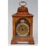 A mid-20th century walnut cased mantel clock, having an arched brass dial with Roman numerals and