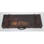 An early 20th century oak, brown leather and brass bound shotgun case, having a red felt lined