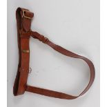 A brown leather Sam Browne belt with brass fittings.