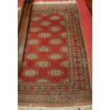 A Persian woollen red ground Bokhara rug, with multiple borders, 183 x 123cm