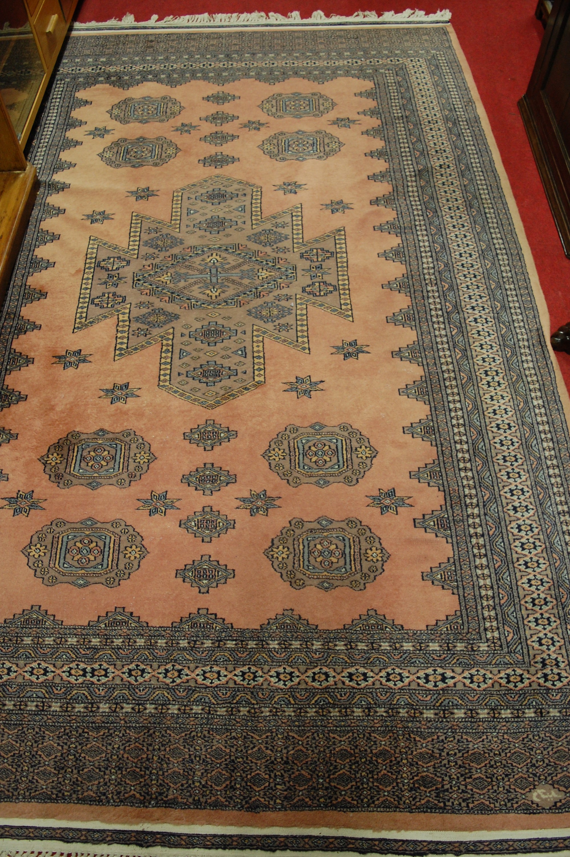 A Persian woollen pink ground Bokhara rug, with multiple trailing borders, 285 x 185cm