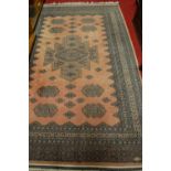 A Persian woollen pink ground Bokhara rug, with multiple trailing borders, 285 x 185cm
