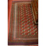 A Persian woollen red ground Bokhara rug, having multiple trailing borders, 200 x 130cm