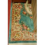 A Chinese Superwash green ground rug, decorated with flowers; and one other similar example (2)