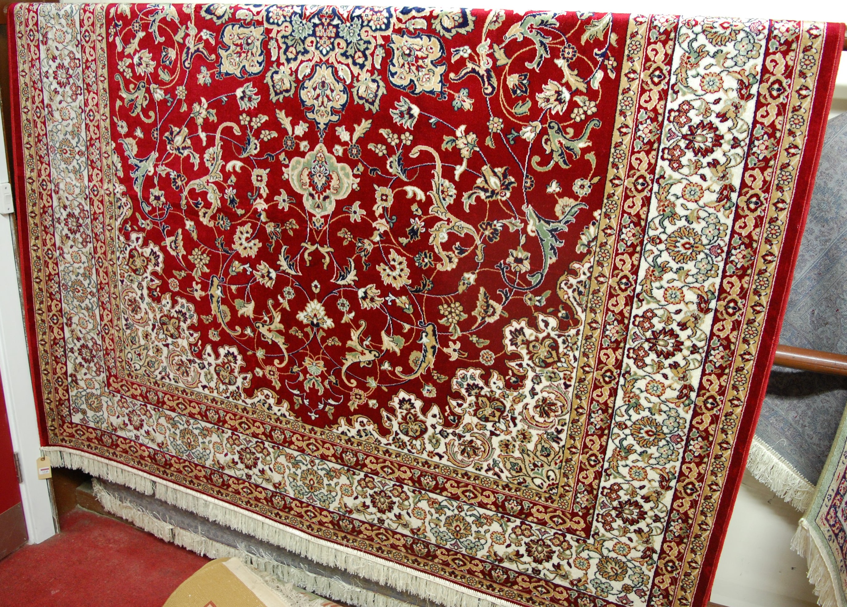 A machine-woven Persian woollen red ground kashan carpet, 300 x 200cm