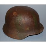 A post-WWII German M35 steel helmet, in camouflage finish