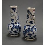 A pair of Chinese export blue and white vases, each having a slender neck to a bulbous lower body,