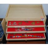 A modern laminate twelve-drawer collectors chest, containing various cap badges (mainly re-strikes),