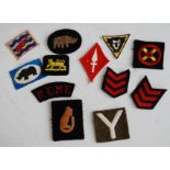 A collection of cloth formation signs, to include 7th Armoured Division, First Army Corps, and Royal